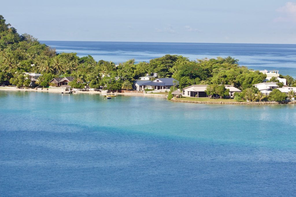 Scenic view of a tropical island resort with clear blue waters and lush greenery, ideal for vacations.