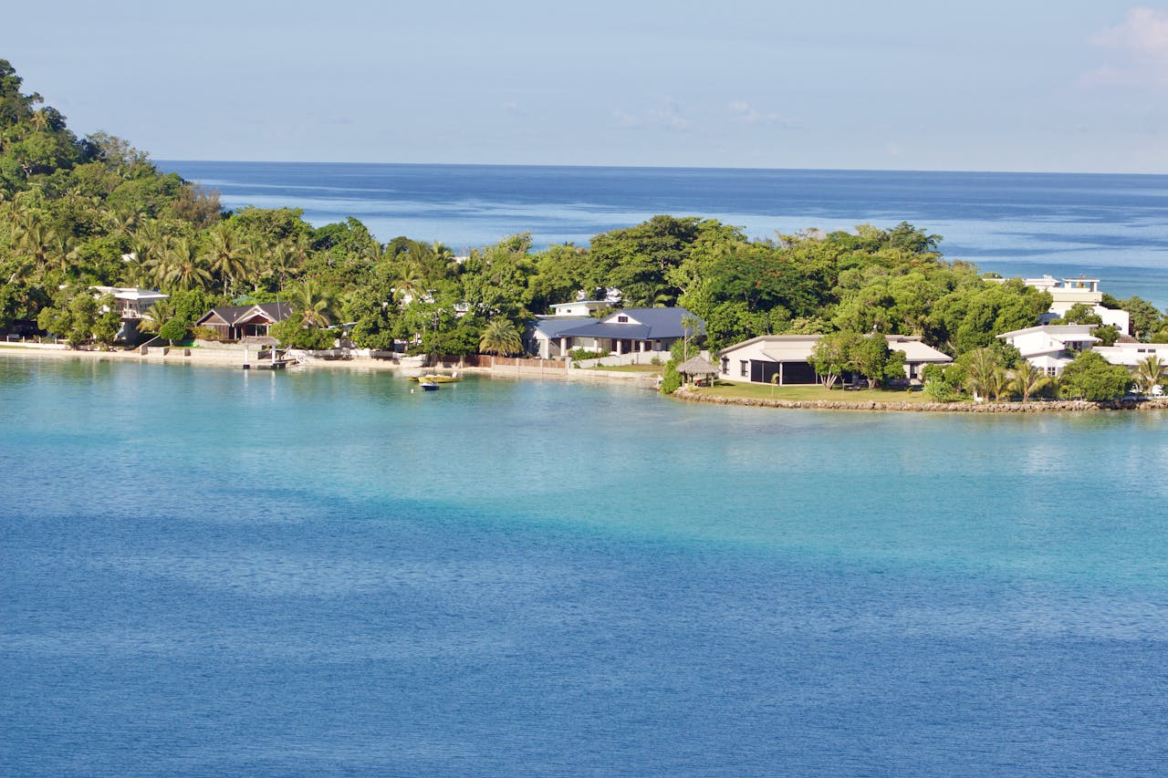 Scenic view of a tropical island resort with clear blue waters and lush greenery, ideal for vacations.